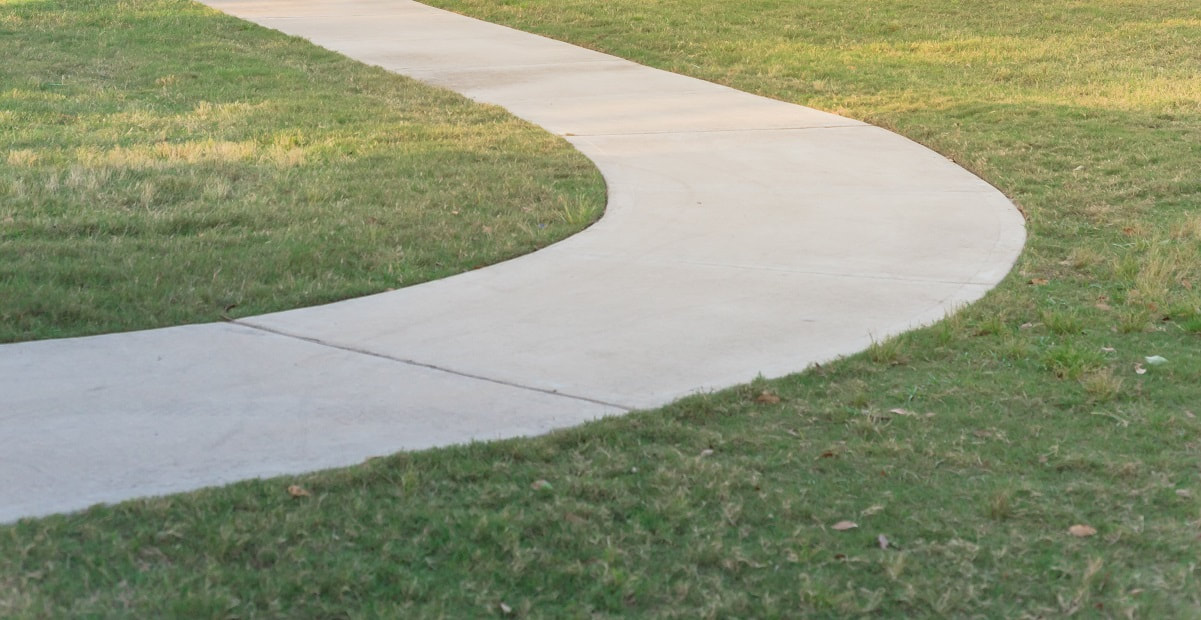 A curved section of concrete sidewalk that has been leveled after sinking